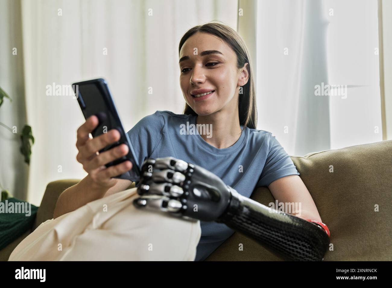 Giovane donna con protesi che usa il telefono cellulare Foto Stock