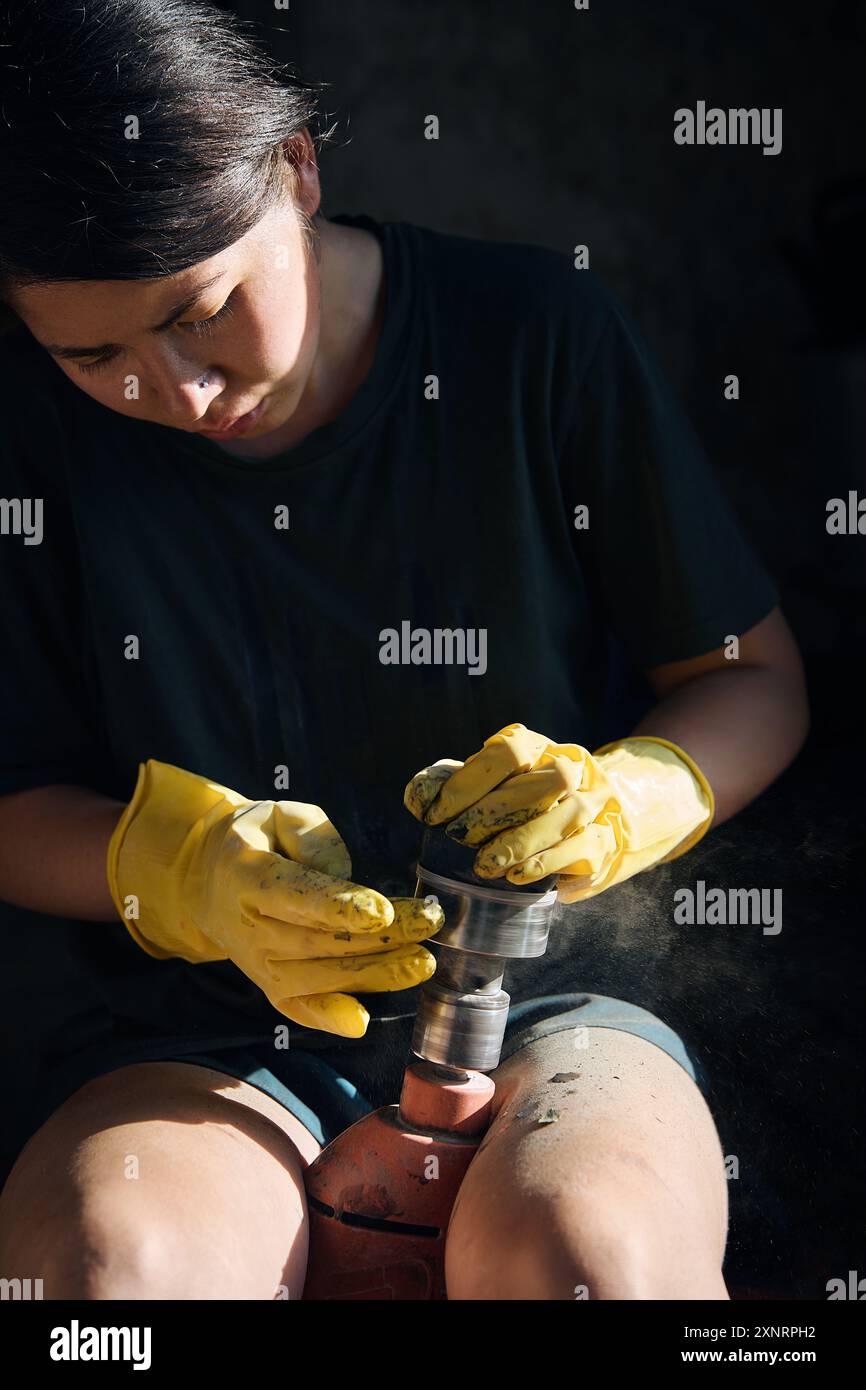 Una donna lucida una pietra con un attrezzo speciale, primo piano Foto Stock