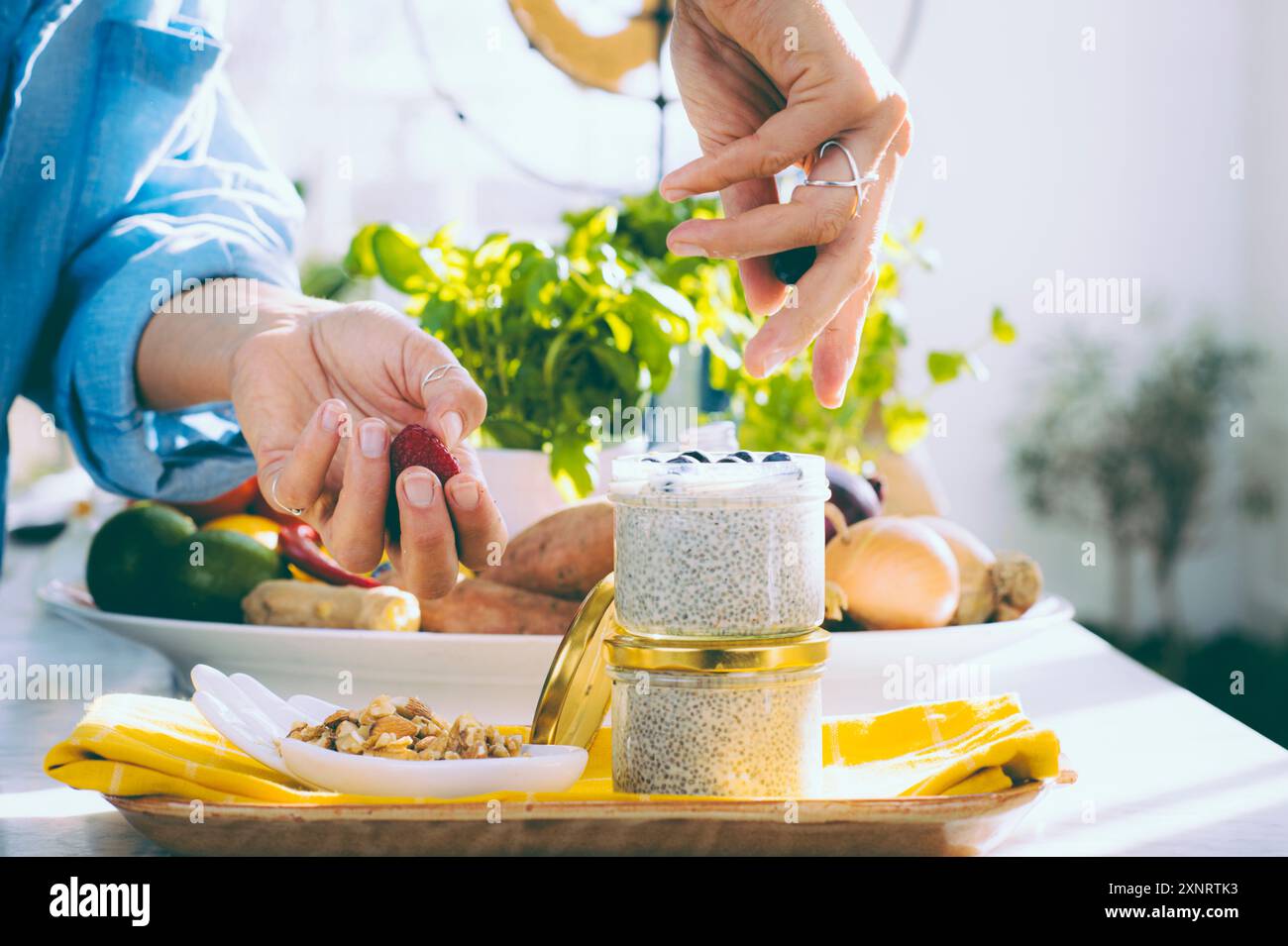 Cucina sana - la donna prepara il budino di chia con le bacche Foto Stock