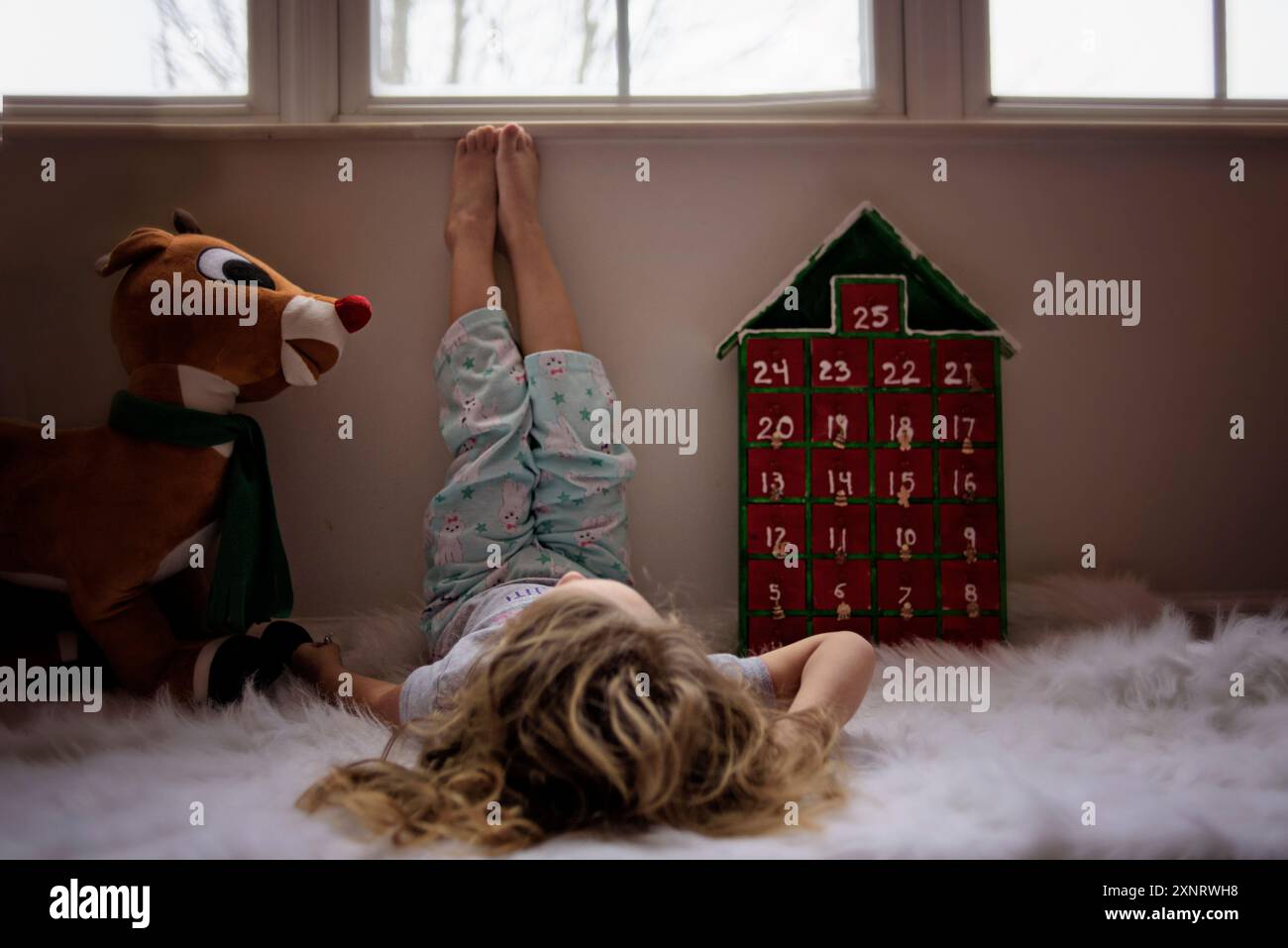 Bambino piccolo con calendario dell'avvento e renne a casa Foto Stock