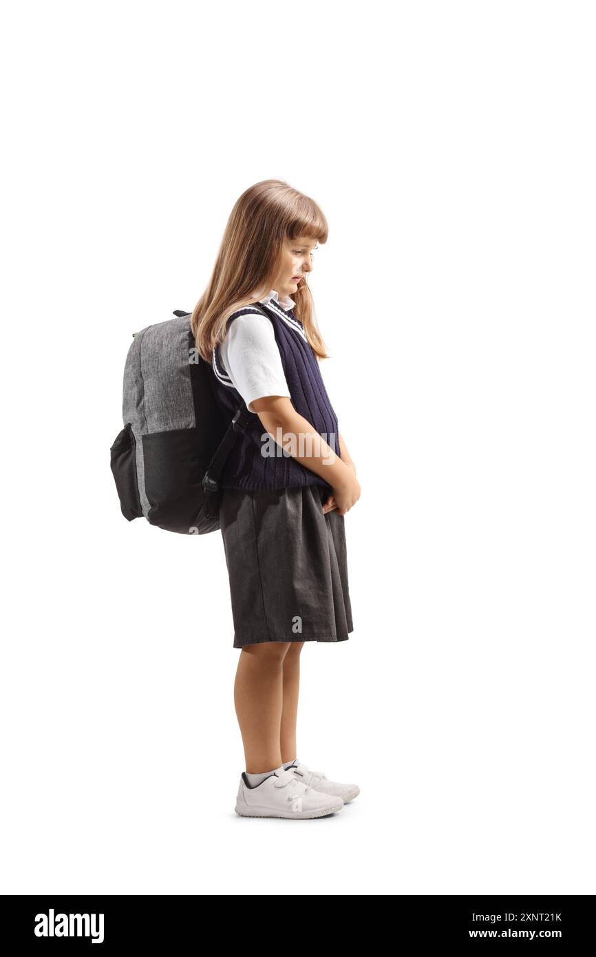 Foto a tutta lunghezza di un'allieva triste in uniforme scolastica isolata su sfondo bianco Foto Stock