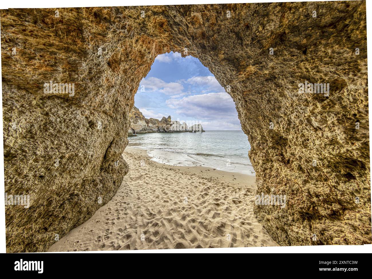 Un arco di sabbia e mare si apre invitante su un'ambientazione da spiaggia Foto Stock