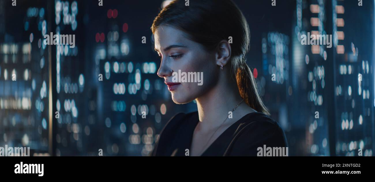 Ritratto di una giovane donna d'affari caucasica di successo seduta alla scrivania che lavora su un computer portatile nell'ufficio della città a tarda notte. Manager Plan Social Media Strategy for e-Commerce Project. Foto Stock