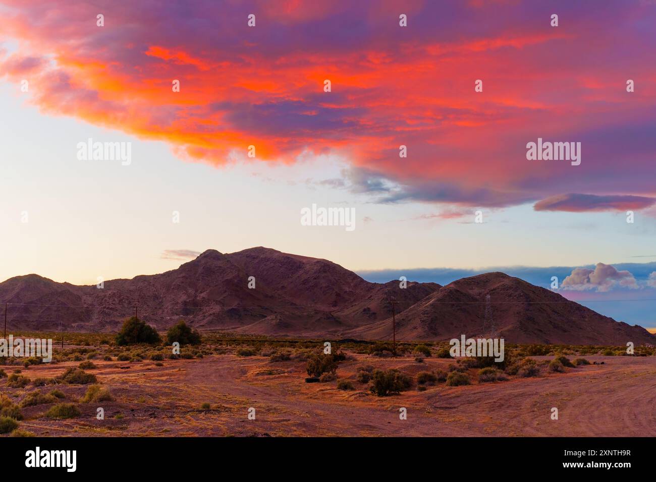 Sereno tramonto di montagna con nuvole che assorbono splendide sfumature di arancione e rosa, incarnando la natura serena dei paesaggi selvaggi della California. Foto Stock
