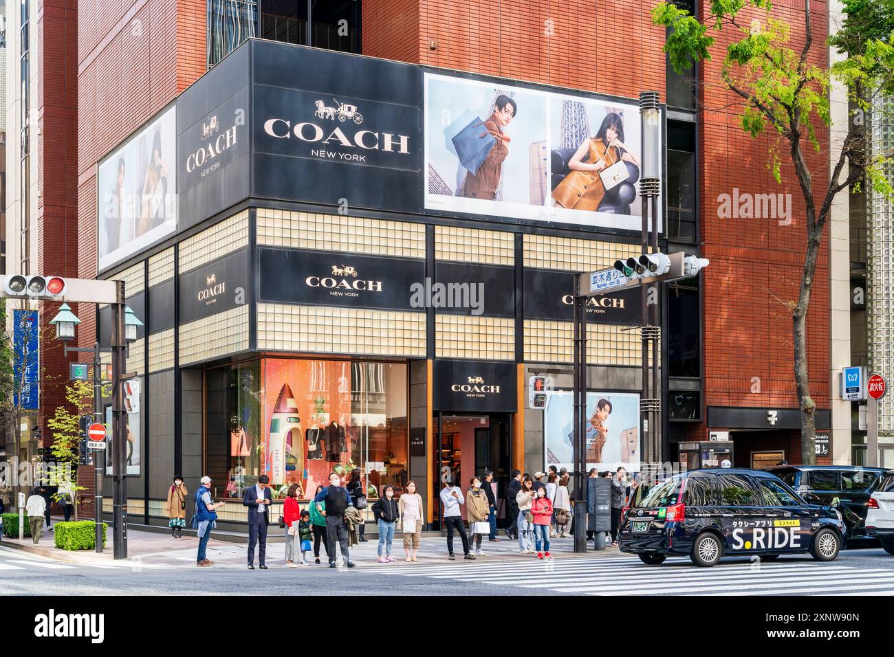 L'elegante negozio di pullman in Ginza in via Namiki-dori, persone fuori dal negozio in attesa di utilizzare l'attraversamento pedonale di fronte. Foto Stock