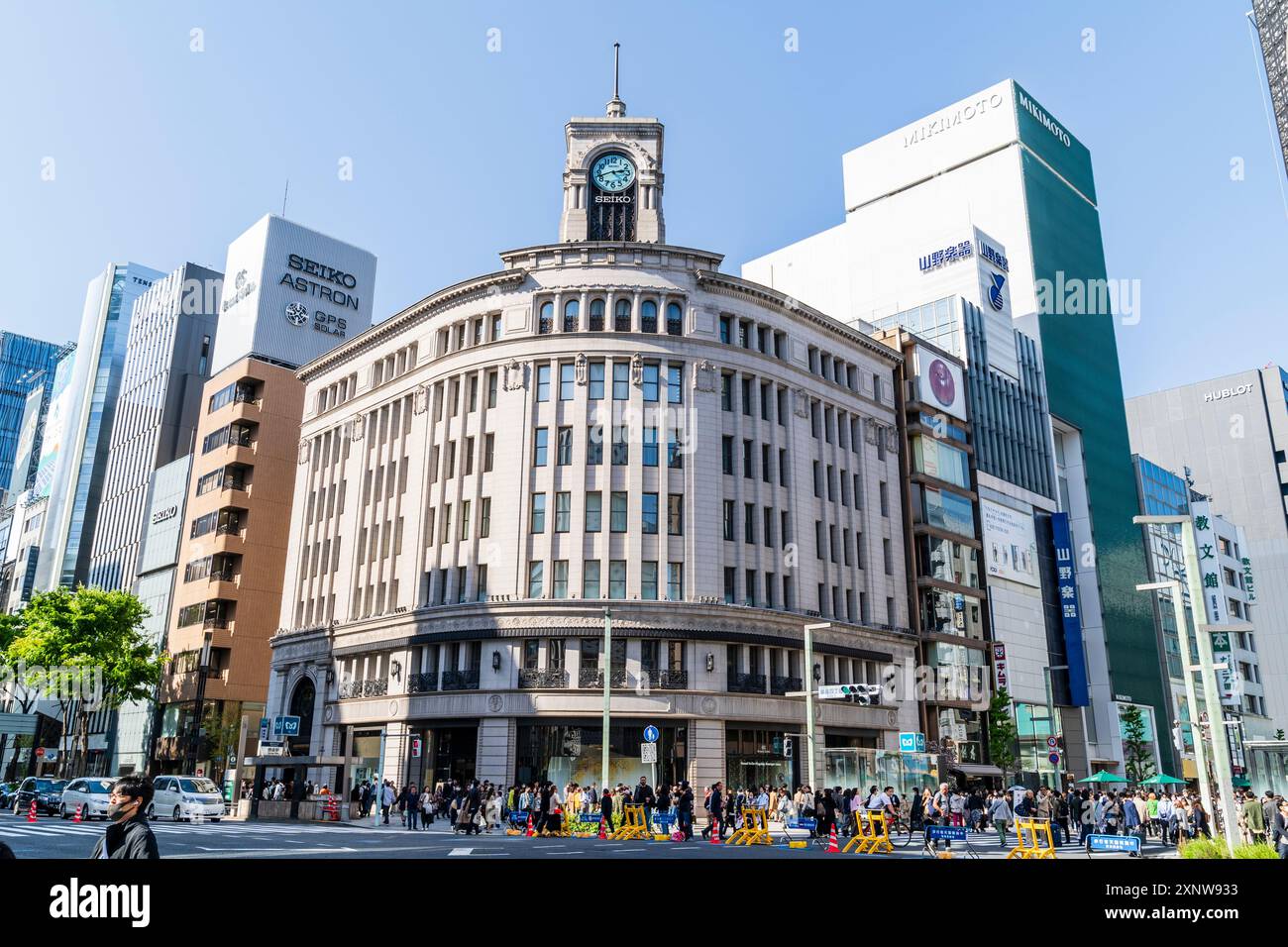 Persone nell'area pedonale di Hokoten della Ginza con le barriere che li separano dal traffico di fronte ai grandi magazzini Wako. Foto Stock