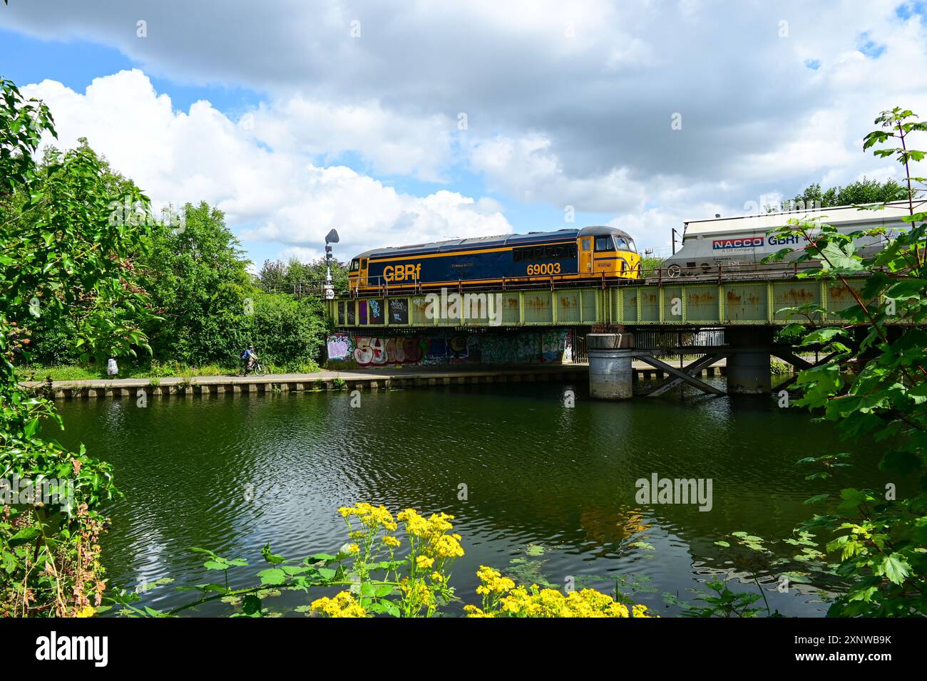 La GB Railfreight classe 69 dirige un carico diretto a nord sul fiume Nene sulla "Hereward Line" verso Peterborough, Cambridgeshire, Inghilterra, Regno Unito Foto Stock
