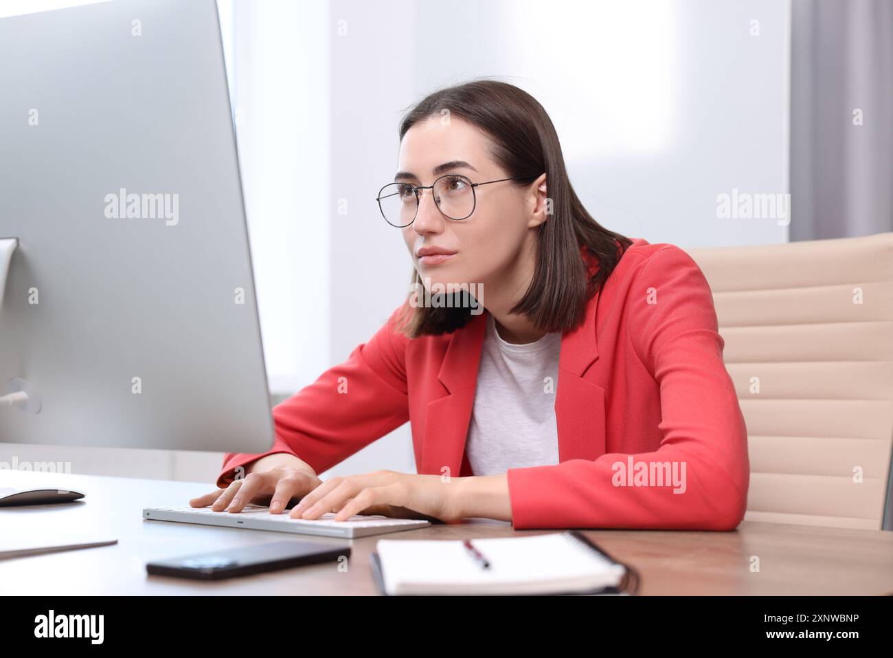 Donna con postura scarsa che lavora in ufficio Foto Stock