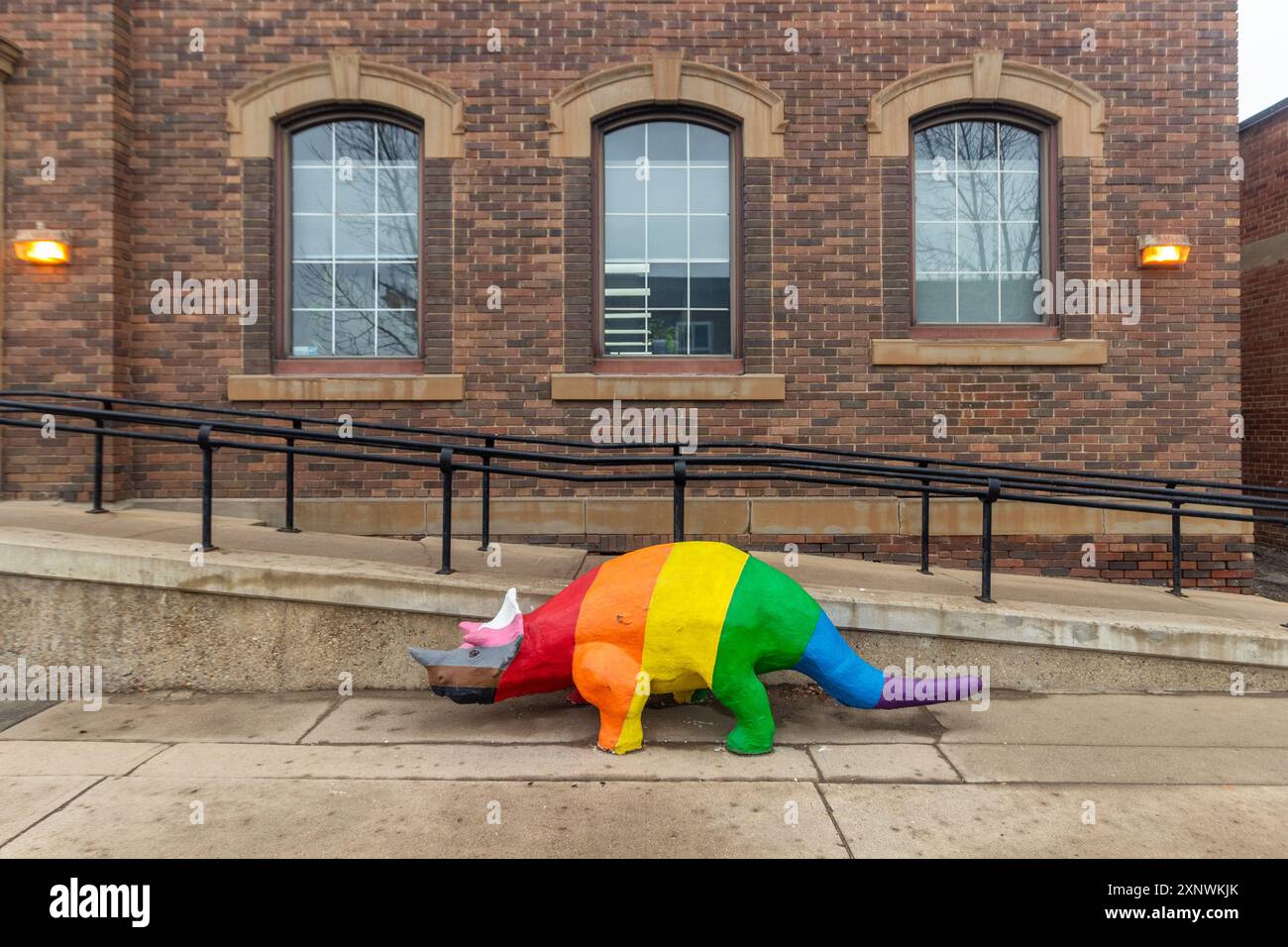 Una scultura di dinosauro dipinta con l'arcobaleno illumina le strade di Drumheller, Alberta, mescolando l'orgoglio preistorico con un'audace spruzzatura di colore nel centro città Foto Stock