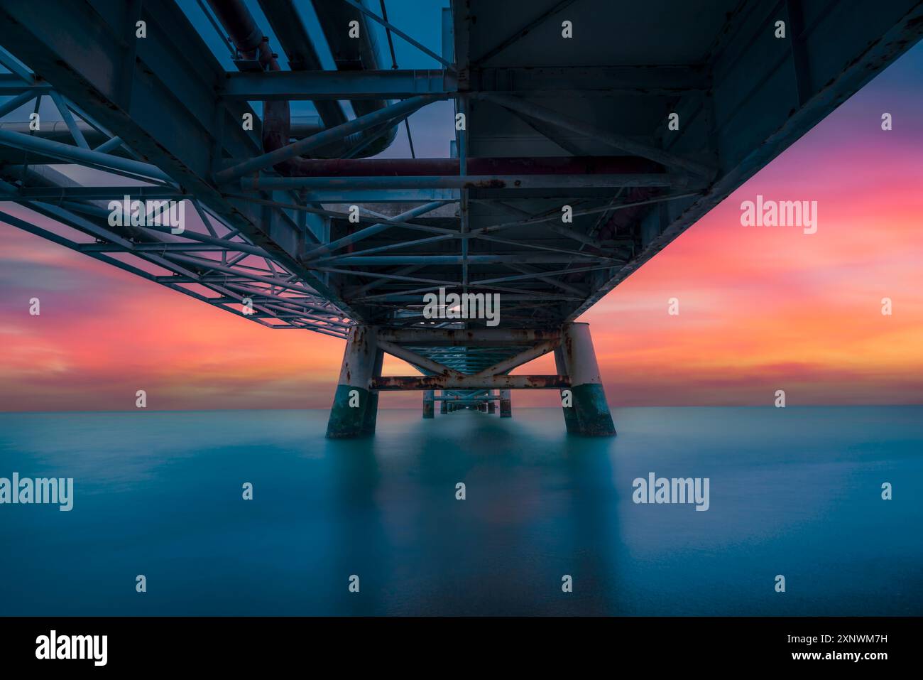 Molo industriale sul mare al tramonto. Fotografia a lunga esposizione. Pontile di vada, regione Toscana, Italia Foto Stock
