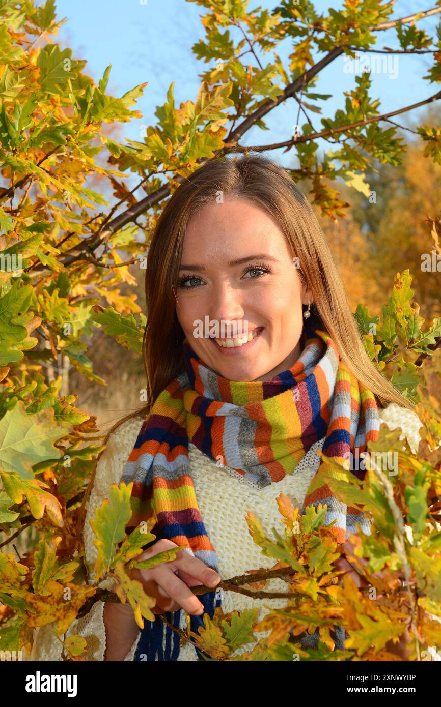 Ritratto di una giovane bella donna sorridente, 30 anni, all'aperto nella foresta con colori autunnali a Ystad, Skane County, Svezia, Scandinavia Foto Stock