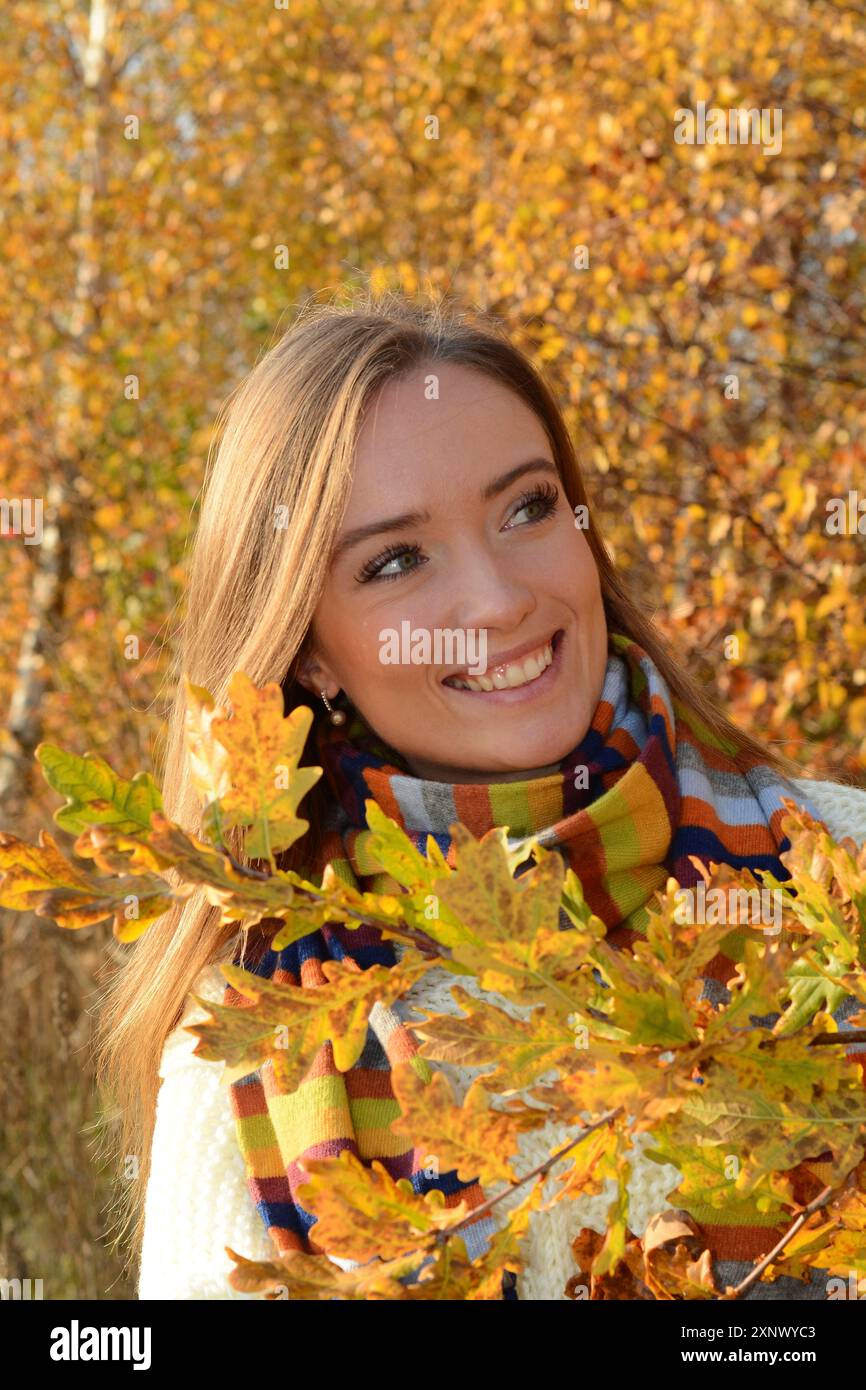 Ritratto di una giovane bella donna sorridente, 30 anni, all'aperto nella foresta con colori autunnali a Ystad, Skane County, Svezia, Scandinavia Foto Stock