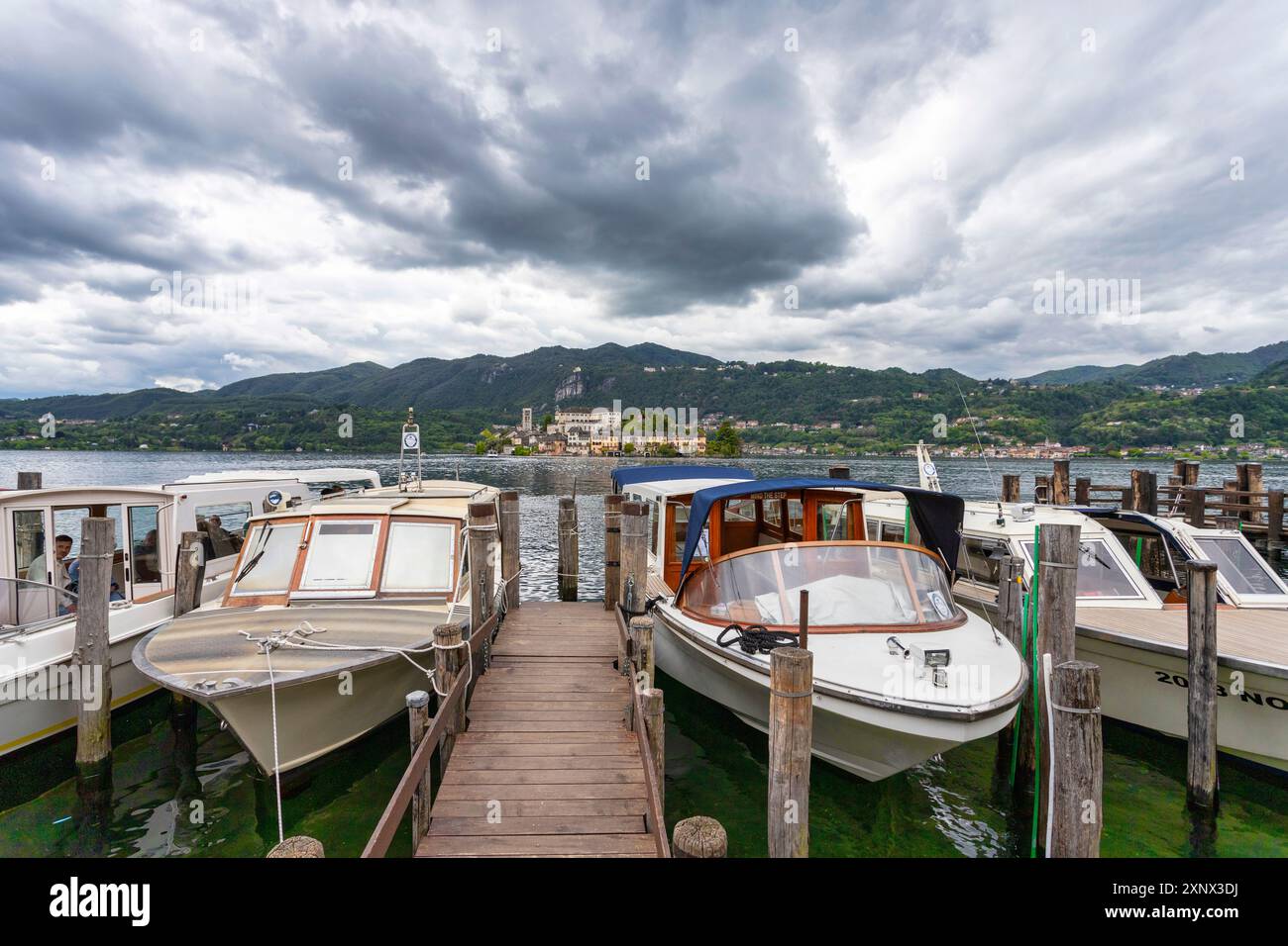 Barche ormeggiate nel piccolo porto di Orta e l'isola di San Giulio sullo sfondo, Orta, Novara, Laghi italiani, Piemonte, Italia, Europa Foto Stock