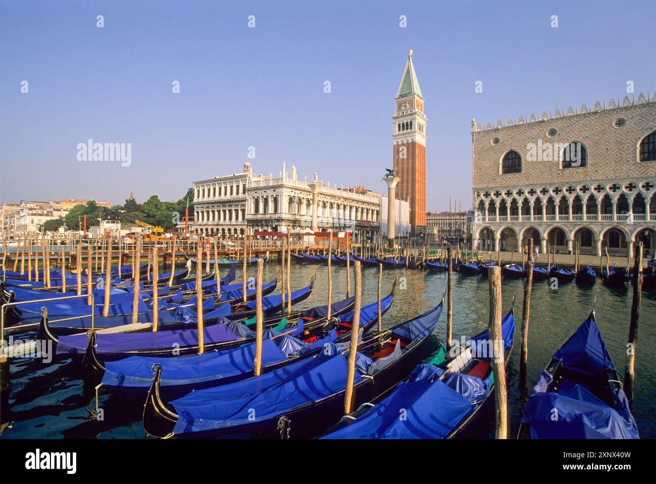 Gondole ormeggiate a Riva degli Schiavoni con il Palazzo dei Dogi e il Campanile di San Marco, Venezia, UNESCO, regione Veneto, Italia Foto Stock