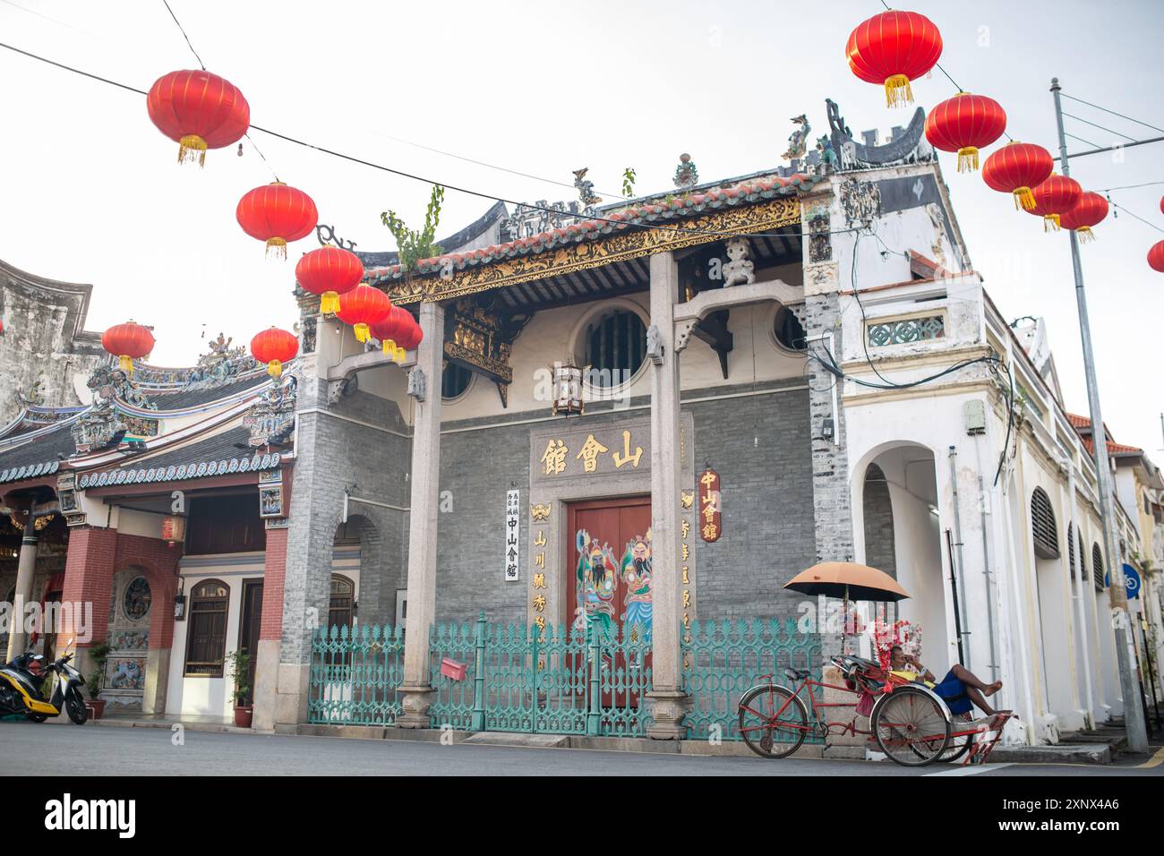 Un autista di risciò che riposa sul lato della strada di George Town, Penang, Malesia, Sud-est asiatico, Asia Foto Stock