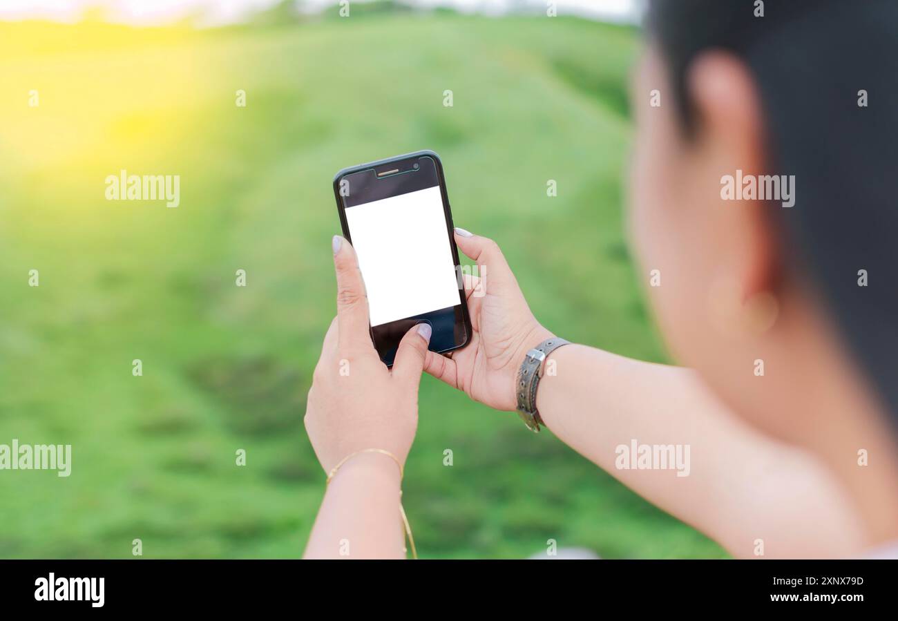 Schermata vuota del cellulare di una ragazza che sta scattando un selfie. Mock-up di una persona che tiene il telefono cellulare con schermo vuoto e crea selfie Foto Stock