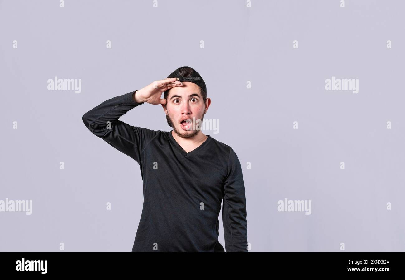 Stupito giovane uomo con la bocca aperta con la mano sulla fronte, sorpreso ragazzo con la bocca aperta con la mano sulla fronte, concetto di Foto Stock