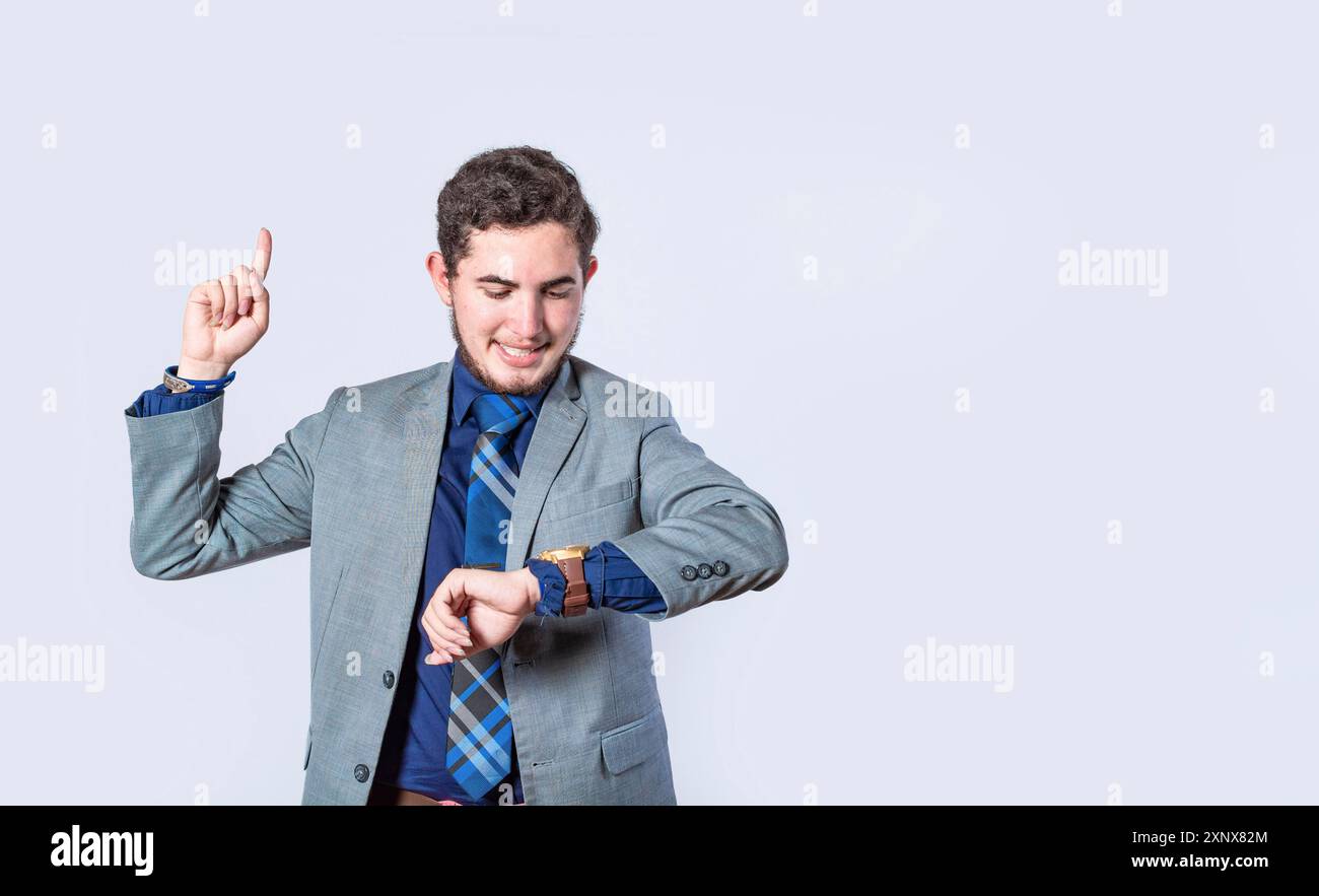 Uomo d'affari scioccato da una nuova idea, uomo sorpreso con la giacca che punta il dito verso l'alto, uomo d'affari che guarda l'orologio e punta verso l'alto Foto Stock