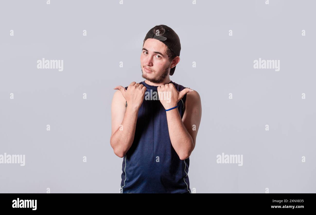 Bell'uomo che punta al lato, ragazzo amichevole che punta le dita al lato, giovane uomo che punta allo spazio vuoto Foto Stock