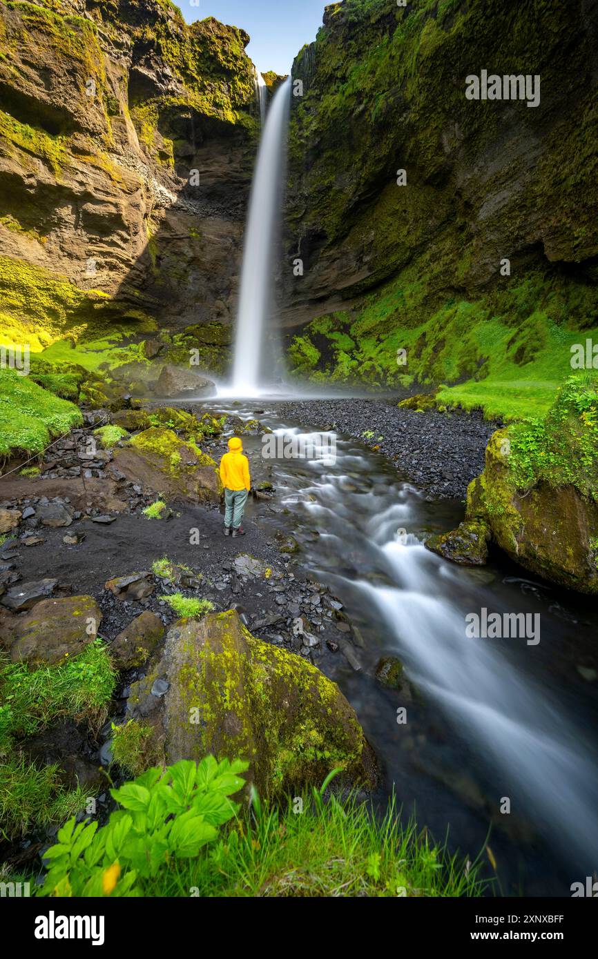 Turista alla cascata di Kvernufoss, in estate quando il tempo è bello, gola e fiume, lunga esposizione, Skogar, Sudurland, Islanda meridionale, Islanda Foto Stock