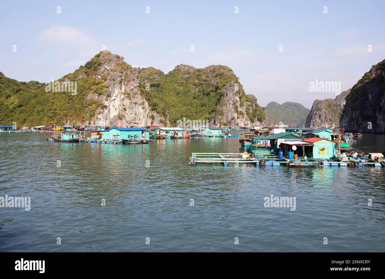 Il villaggio galleggiante di pescatori di Cai Beo e le rocce carsiche nella baia di LAN ha, nella baia di ha Long, in Vietnam Foto Stock