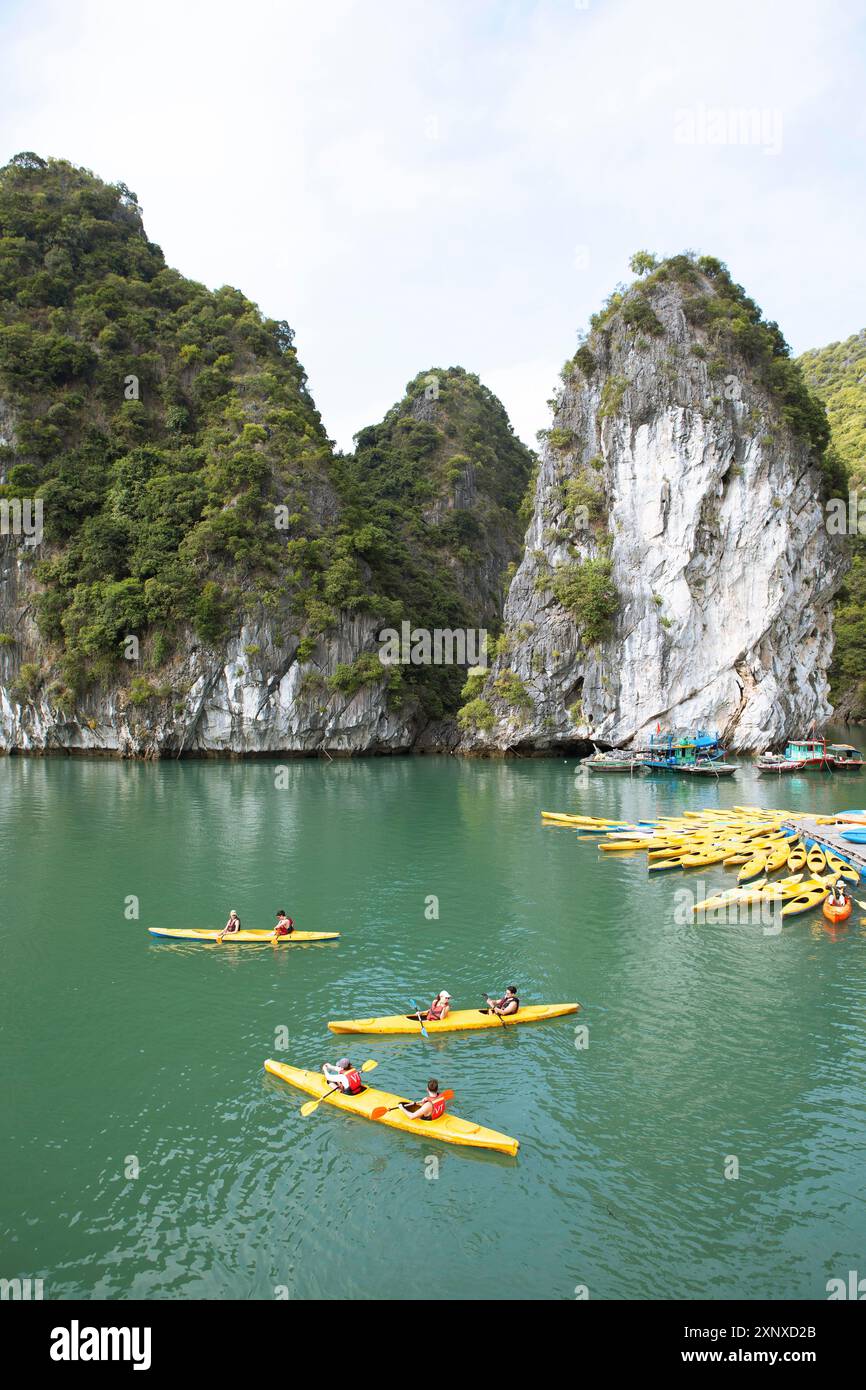 Kayak gialli in un molo e rocce carsiche nella baia di LAN ha, nella baia di ha Long, in Vietnam Foto Stock