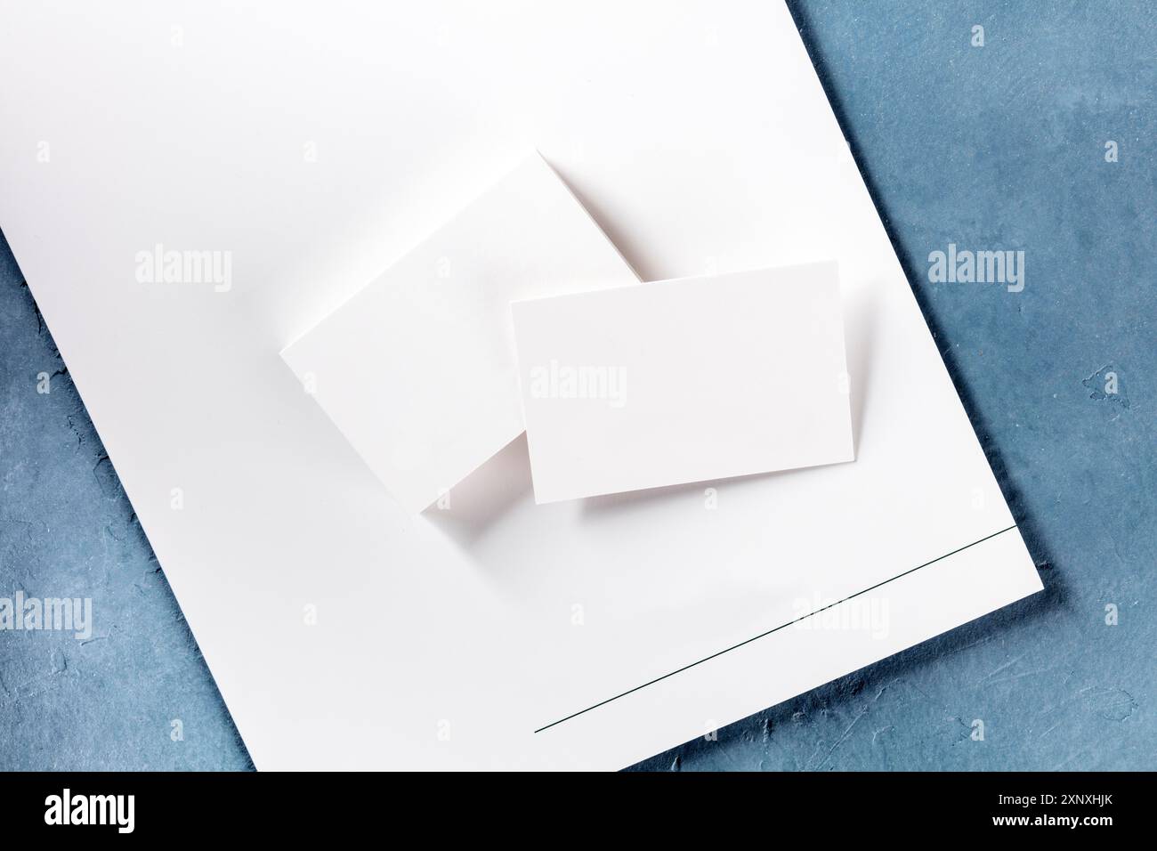 Biglietti da visita vuoti e una cartella, girato dall'alto, un mock-up per una presentazione di design di stile aziendale Foto Stock