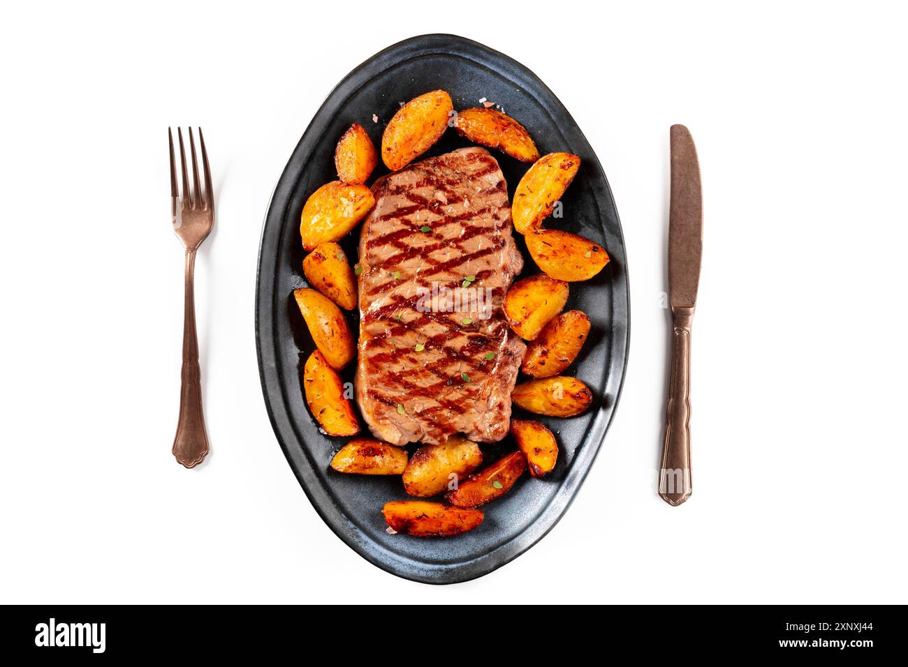 Bistecca di manzo alla griglia con zeppe di patate al forno, tirata dall'alto su sfondo bianco Foto Stock