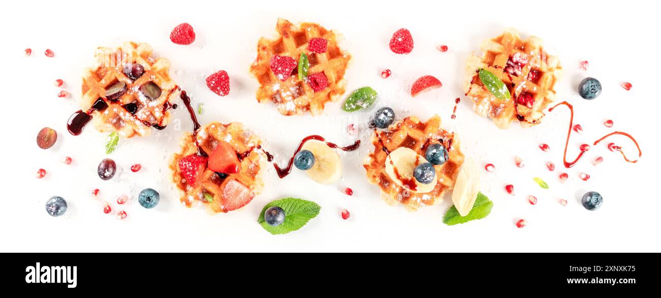 Waffle belgi con frutta fresca e sciroppo, sparati dall'alto su sfondo bianco Foto Stock