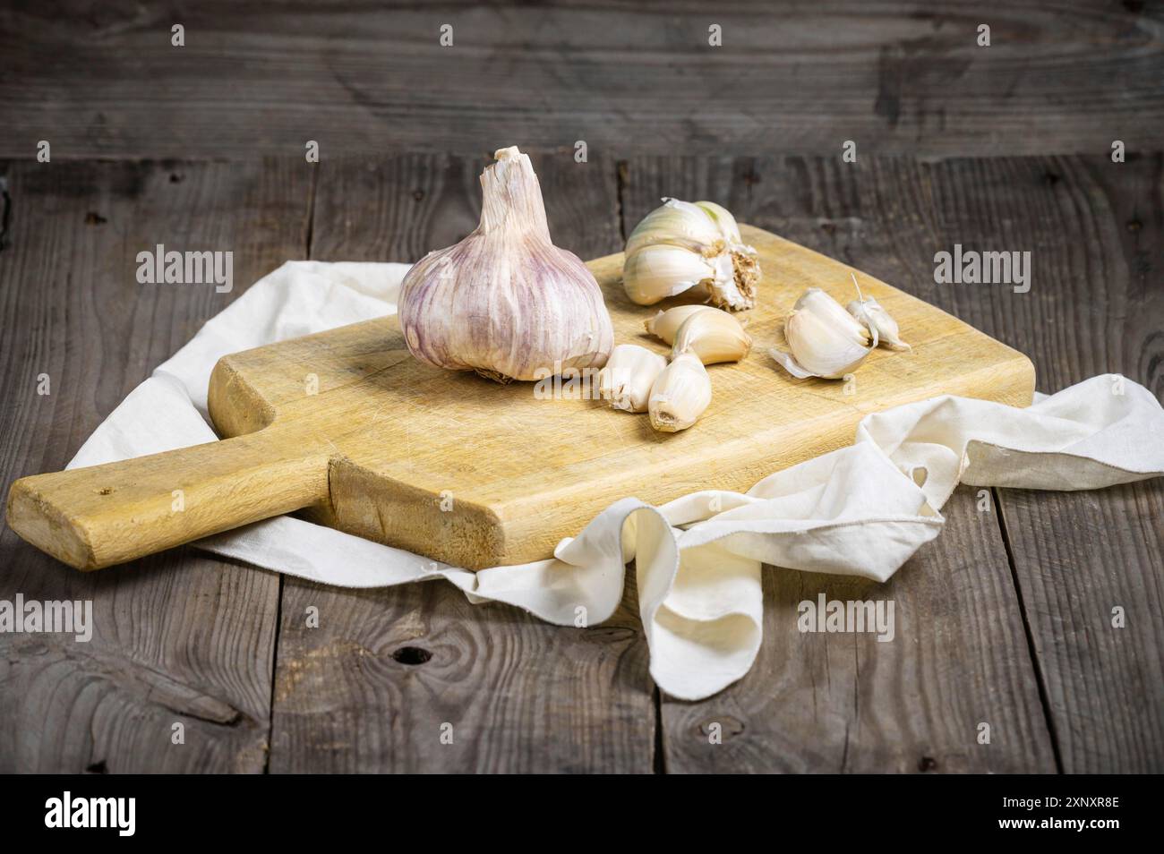 Natura morta vintage con aglio su tavola di legno Foto Stock