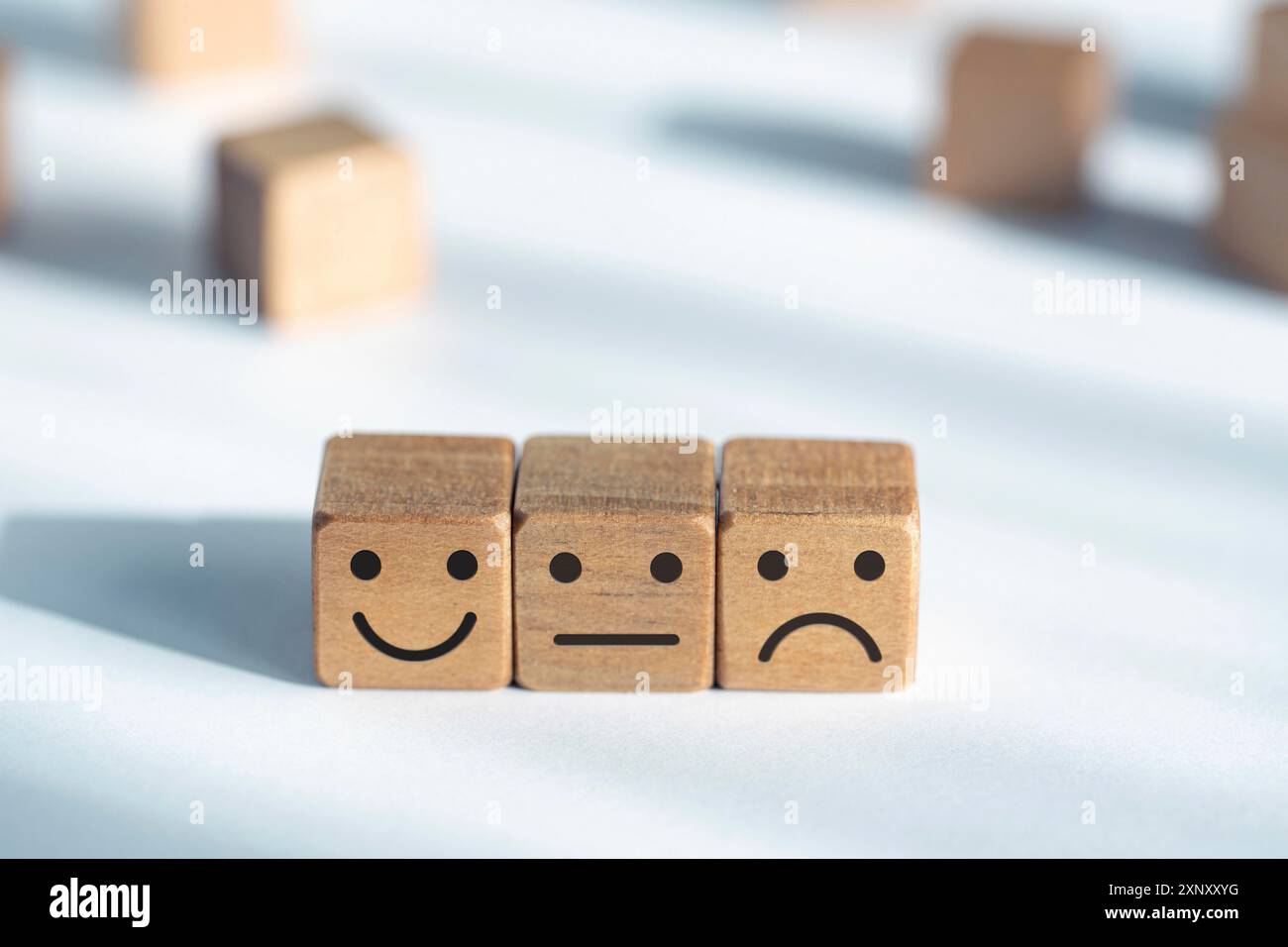 Concetto di valutazione del servizio. Valutazione del feedback. Icona smiley su dadi di legno Foto Stock