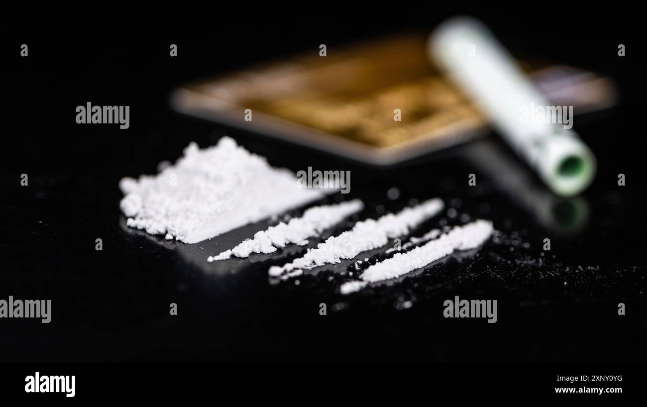 Piatto scuro con una porzione di cocaina come primo piano Foto Stock