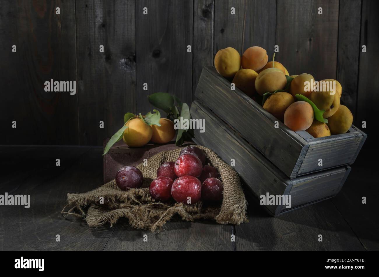Raccolta di frutti di bosco maturi e succosi su sfondo di legno scuro in uno stile rustico Foto Stock