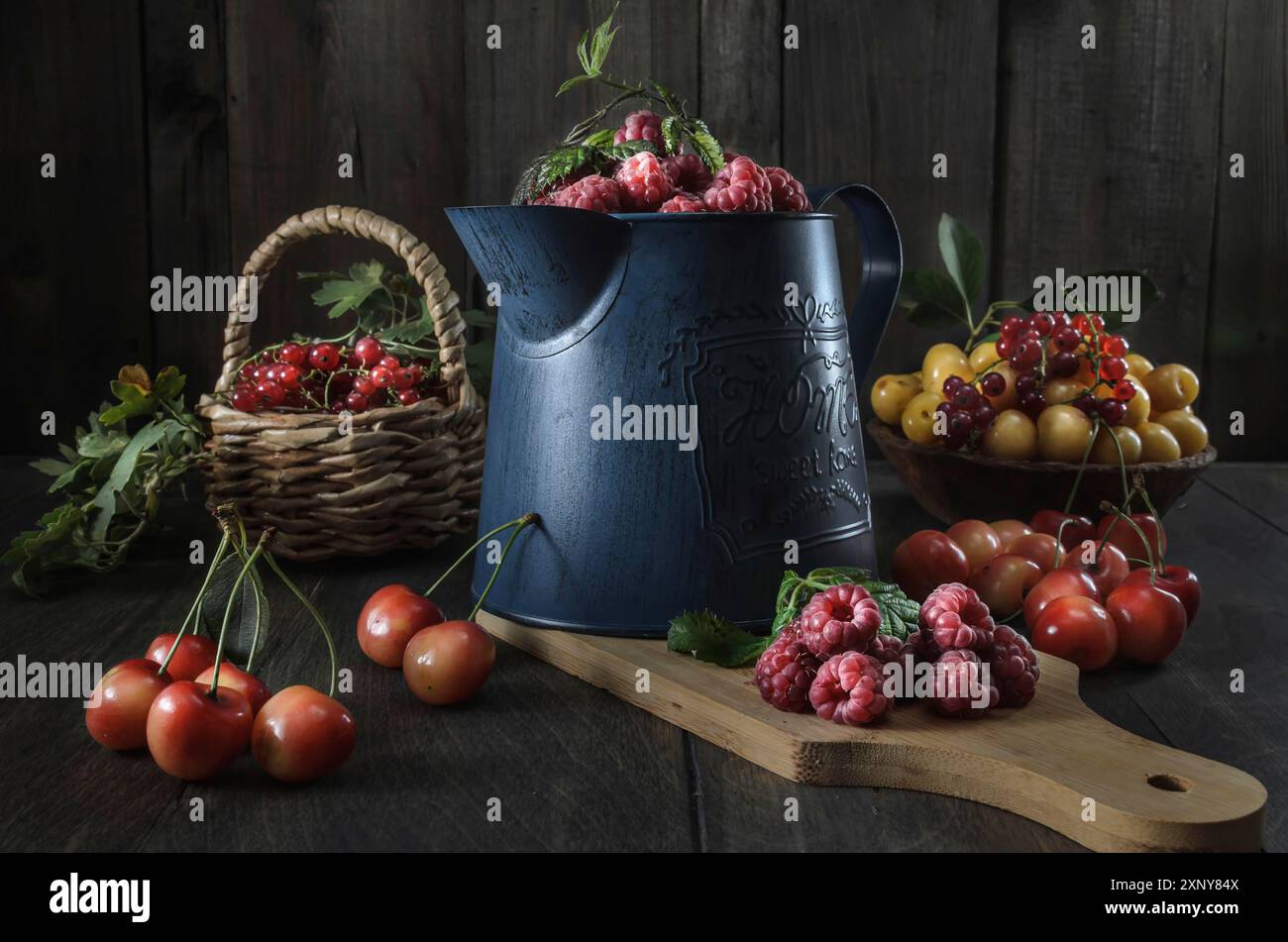 Raccolta di frutti di bosco maturi e succosi su sfondo di legno scuro in uno stile rustico Foto Stock