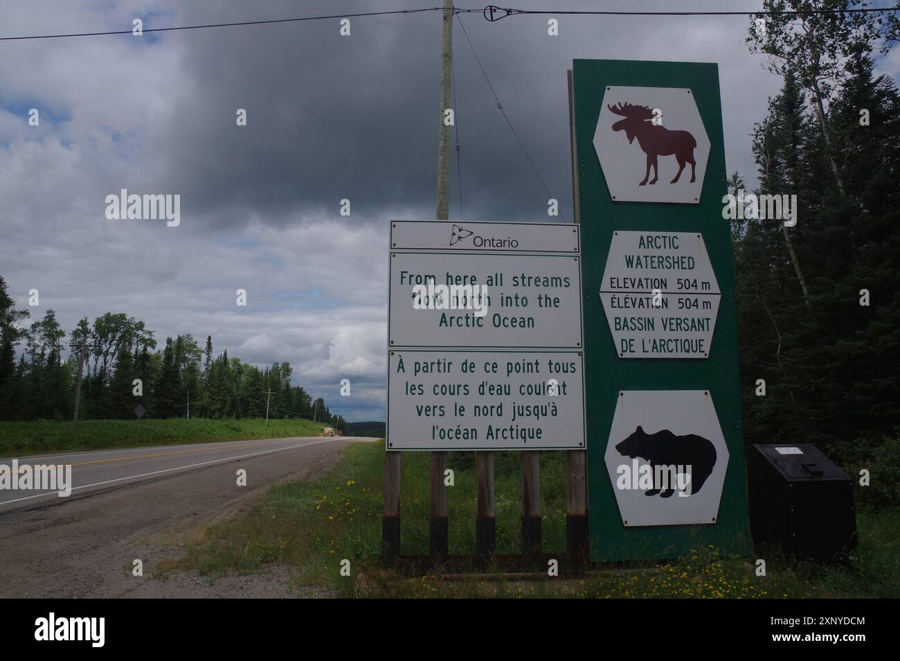 Segnali stradali e segnali stradali in un'area boscosa rurale in una giornata nuvolosa, spartiacque, Manitoba, Canada Foto Stock