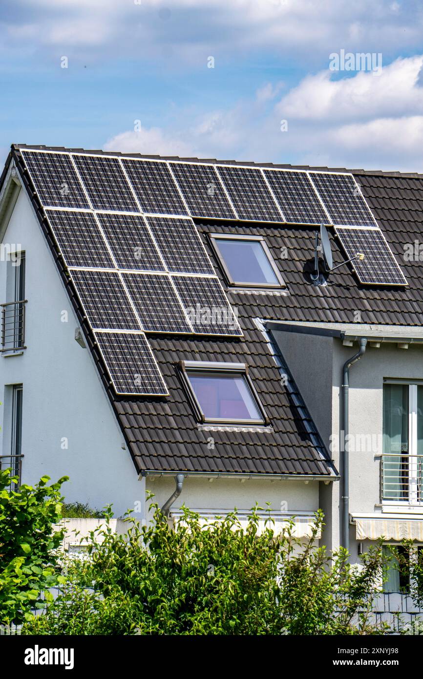 Tetto solare, pannelli solari su un tetto a falda di un edificio residenziale, generazione di energia rinnovabile Foto Stock