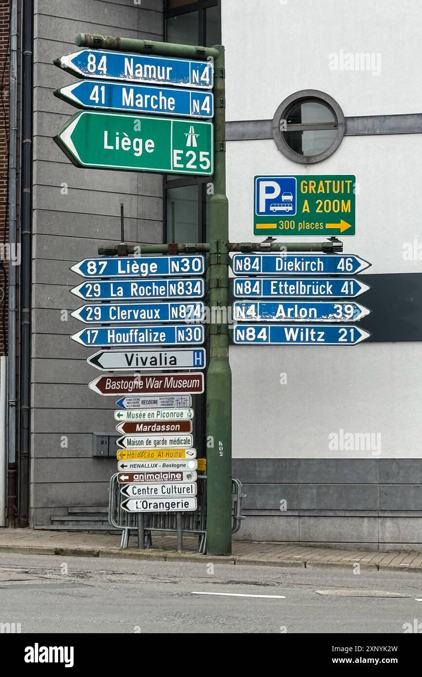 Bastogne / Belgio - 3 luglio 2024: Diversi cartelli stradali indicano la strada per varie città e punti di interesse dal centro di Bastogne. Foto Stock