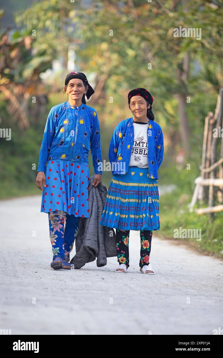 Due donne della minoranza hmong in abiti di tutti i giorni stanno su una strada e guardano nella telecamera, Du gia, provincia di ha Giang, Vietnam Foto Stock