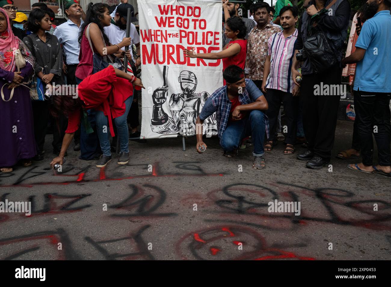 Dacca, Bangladesh. 2 agosto 2024. Gli studenti tengono uno striscione mentre gli altri scrivono a terra durante la dimostrazione. Attivisti del Bangladesh, insegnanti, tutori, artisti, rappresentanti della società civile e leader di varie organizzazioni studentesche hanno protestato contro il primo ministro Sheikh Hasina e il suo governo e hanno chiesto giustizia per più di 200 persone uccise nelle violente manifestazioni del mese scorso a Dacca, Bangladesh. Credito: SOPA Images Limited/Alamy Live News Foto Stock