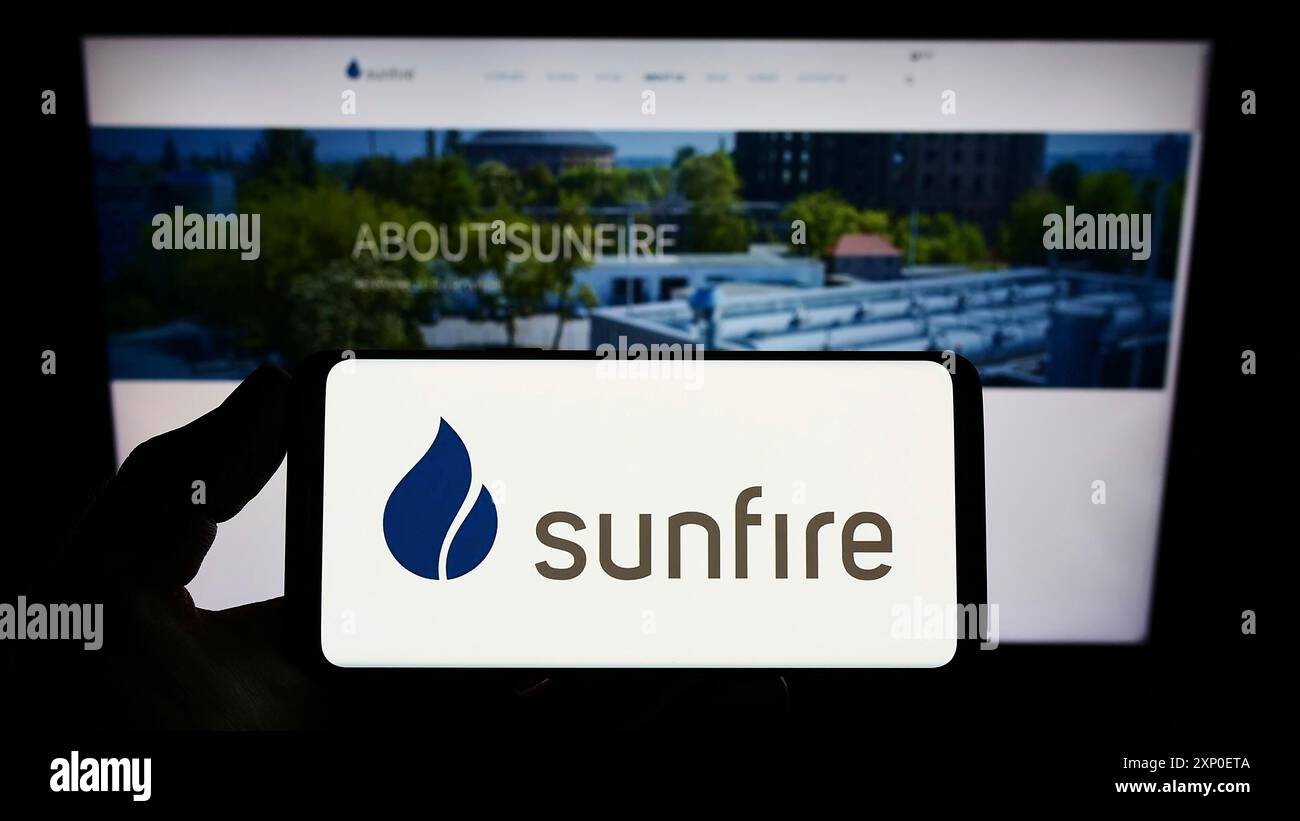 Stoccarda, Germania, 03-29-2022: Persona che possiede uno smartphone con il logo della società tedesca di energia rinnovabile Sunfire GmbH sullo schermo davanti al sito web. Foto Stock