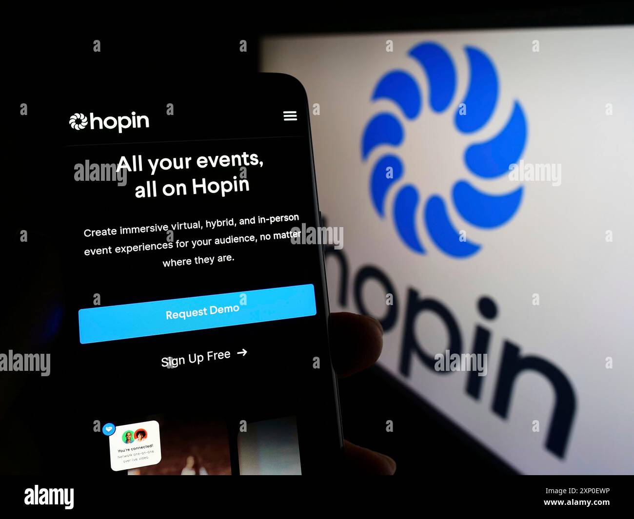Stoccarda, Germania, 03-29-2022: Persona che detiene lo smartphone con pagina web della società britannica di gestione eventi Hopin Ltd. Sullo schermo con logo. Concentrati su Foto Stock