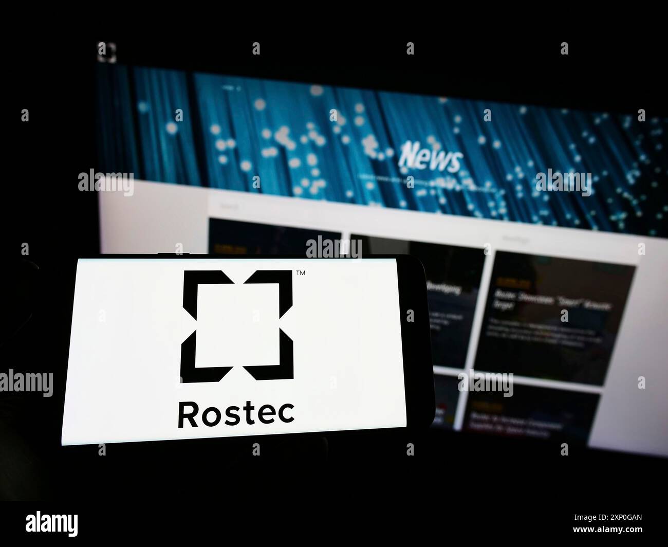 Stoccarda, Germania, 05-08-2022: Persona che detiene un telefono cellulare con il logo della società di difesa russa Rostec sullo schermo di fronte alla pagina web aziendale. Foto Stock