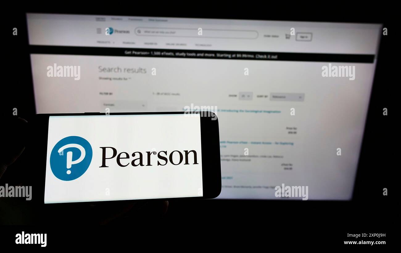 Stoccarda, Germania, 01-30-2022: Persona che possiede uno smartphone con il logo della casa editrice britannica Pearson plc sullo schermo davanti al sito Web. Concentrati su Foto Stock