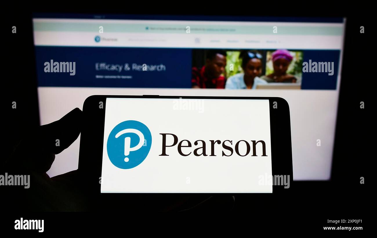 Stoccarda, Germania, 01-30-2022: Persona che detiene un telefono cellulare con il logo della casa editrice britannica Pearson plc sullo schermo davanti al web aziendale Foto Stock