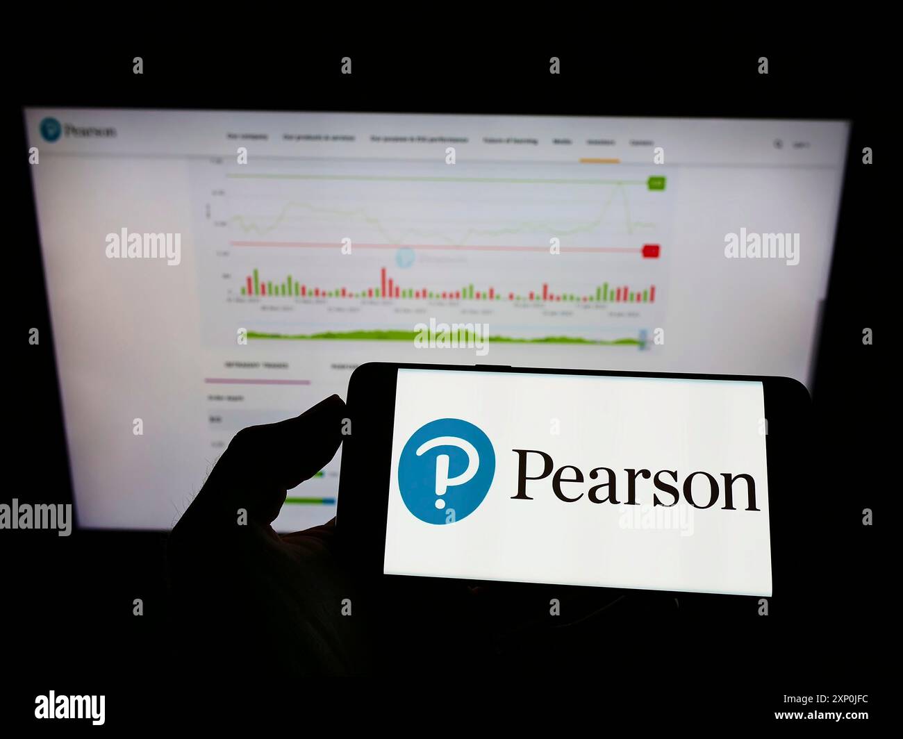 Stoccarda, Germania, 01-30-2022: Persona che detiene il cellulare con il logo della casa editrice britannica Pearson plc sullo schermo di fronte alla pagina web aziendale. Foto Stock
