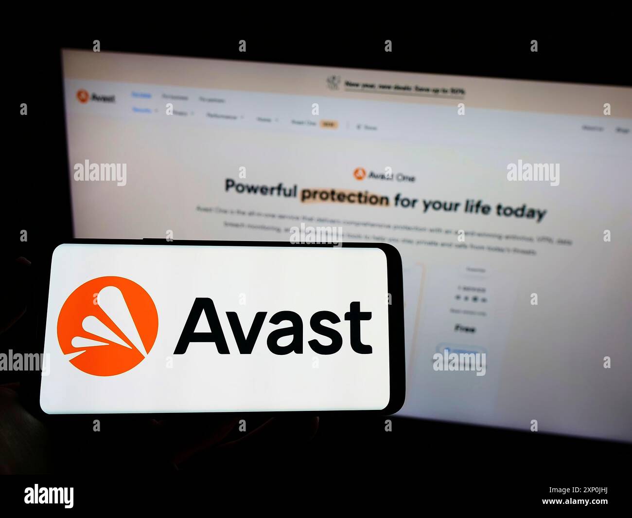 Stoccarda, Germania, 01-29-2022: Persona che detiene un telefono cellulare con il logo della società di sicurezza informatica Avast software s.r.o. sullo schermo di fronte alla pagina web. Foto Stock