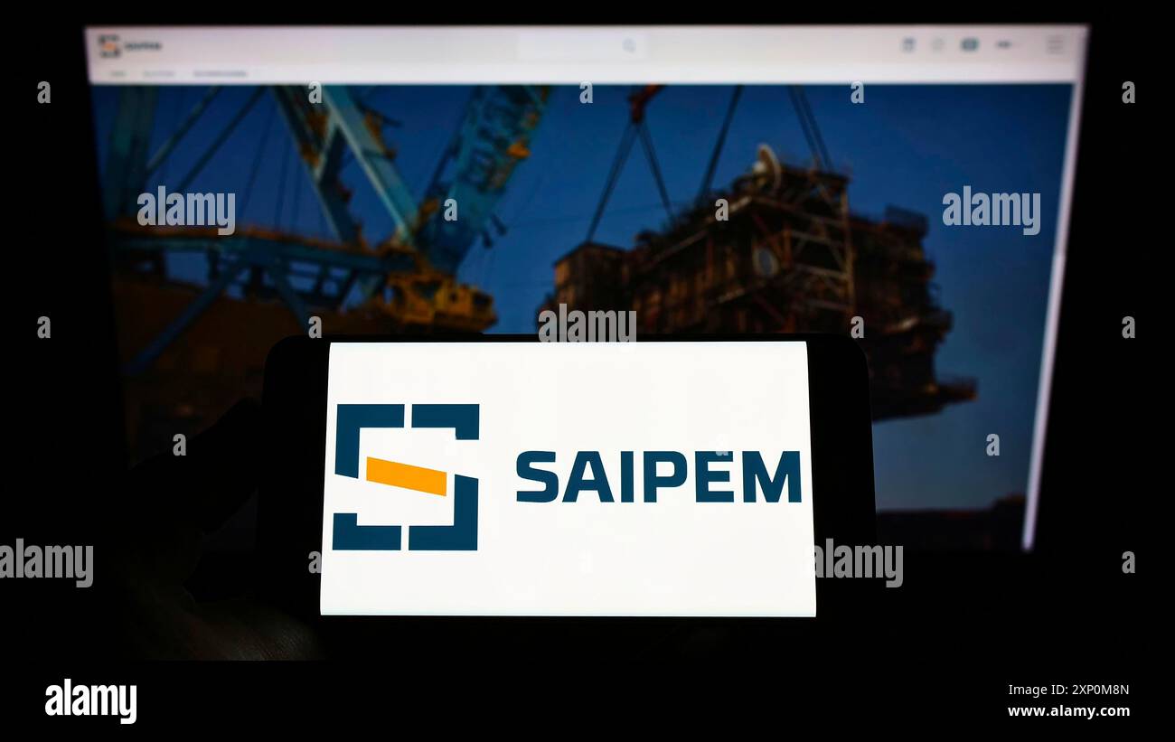 Stoccarda, Germania, 01-09-2022: Persona che detiene un cellulare con il logo della società italiana di servizi petroliferi Saipem S.p.A. sullo schermo di fronte al web Foto Stock