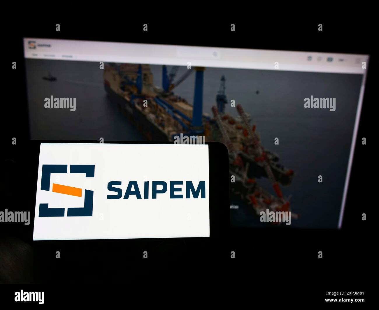 Stoccarda, Germania, 01-09-2022: Persona che detiene il cellulare con il logo della società italiana di servizi petroliferi Saipem S.p.A. sullo schermo di fronte alla pagina web. Foto Stock