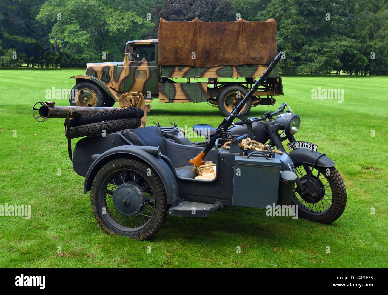Motocicletta tedesca d'epoca e sidecar isolati sull'erba del camion militare Citroen parcheggiato dietro. Foto Stock