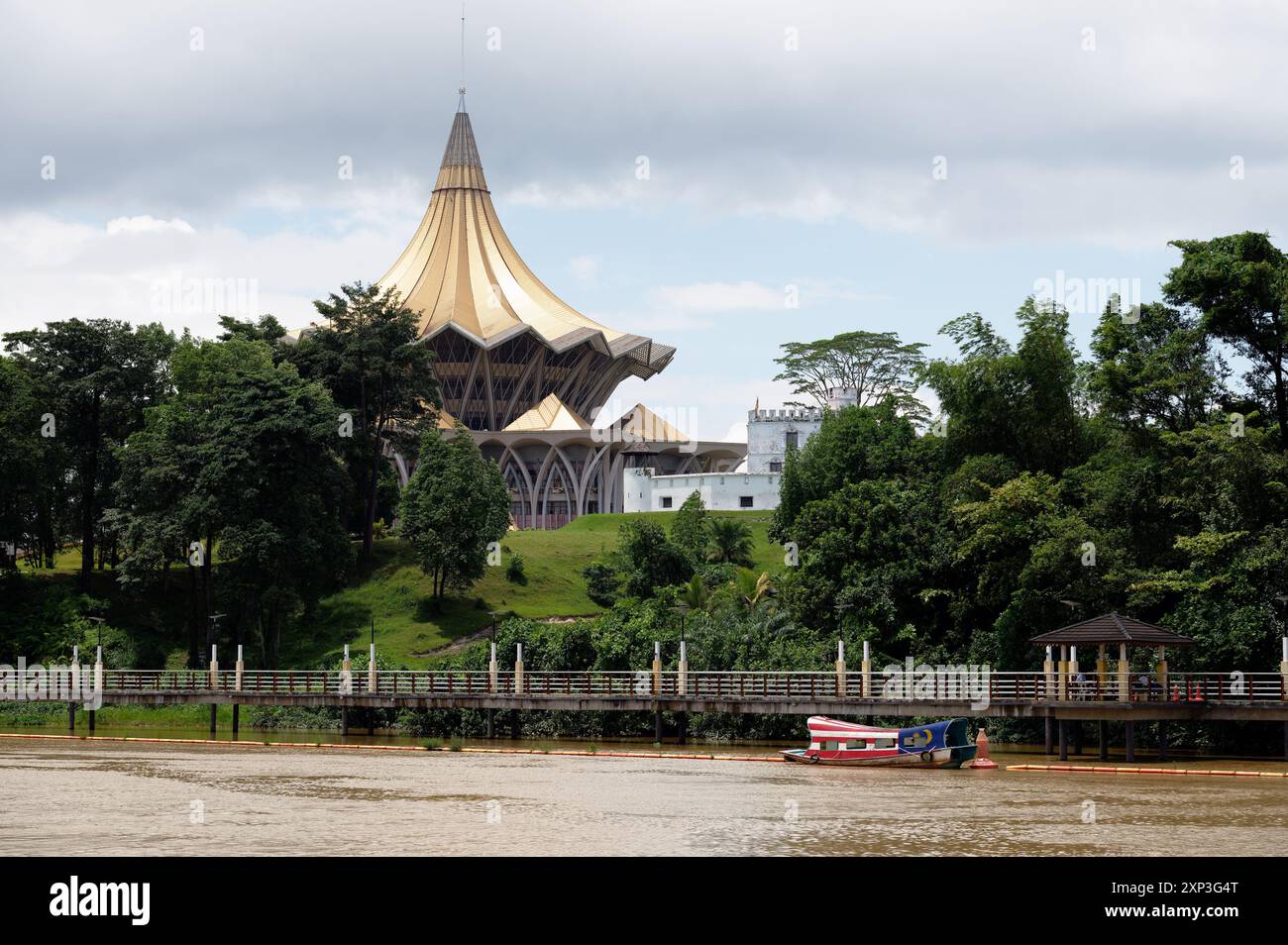 Il nuovo edificio in stile malese dello Stato di Bangunan Dewan Undangan e il coloniale britannico Fort Margherita lungo il Sungai Sarawak, Kuching, Malesia Foto Stock